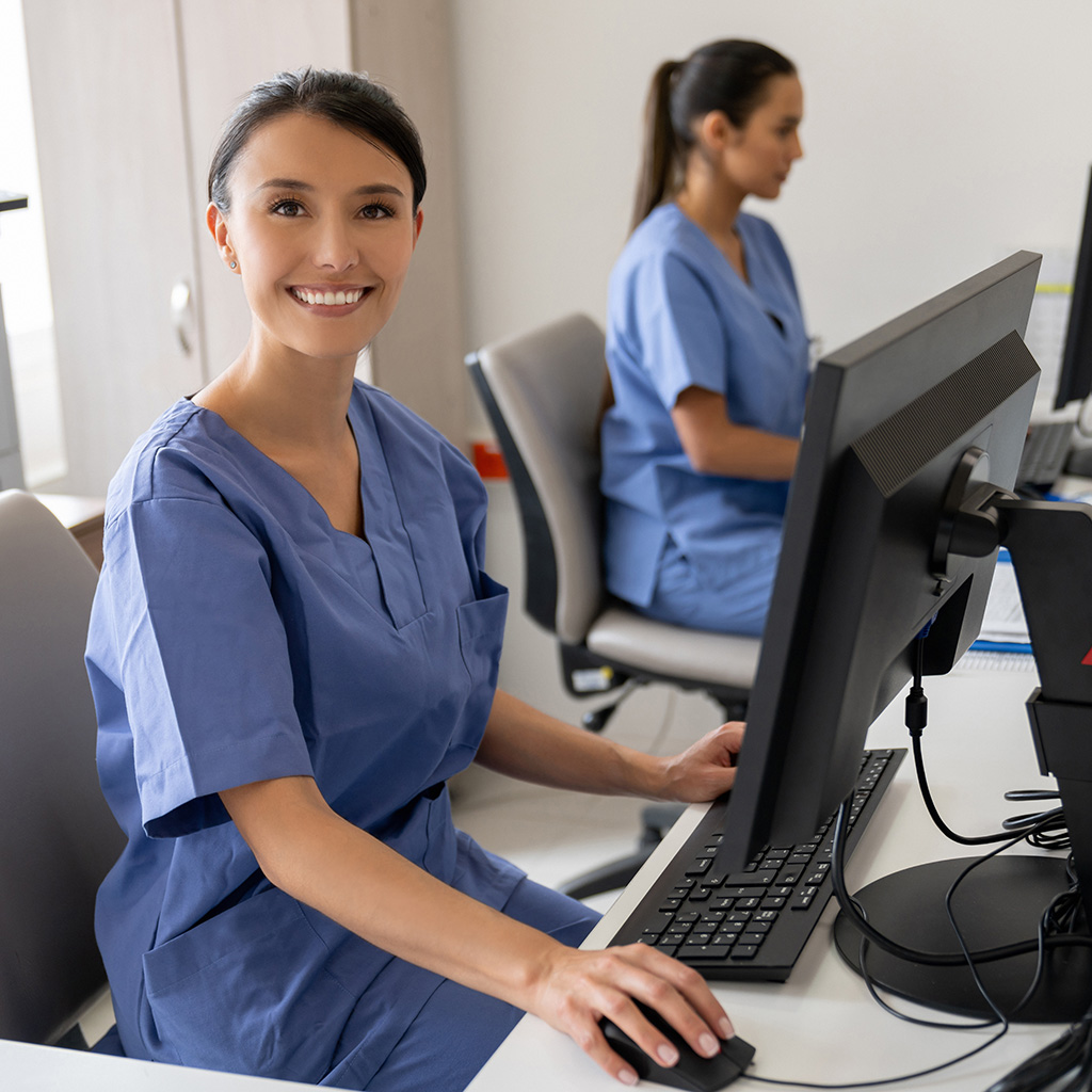 Happy receptionists working at a hospital and looking at the camera smiling - healthcare workers concepts